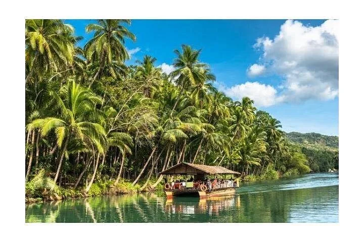A scenic Loboc River Cruise with a floating restaurant passing tropical palm trees